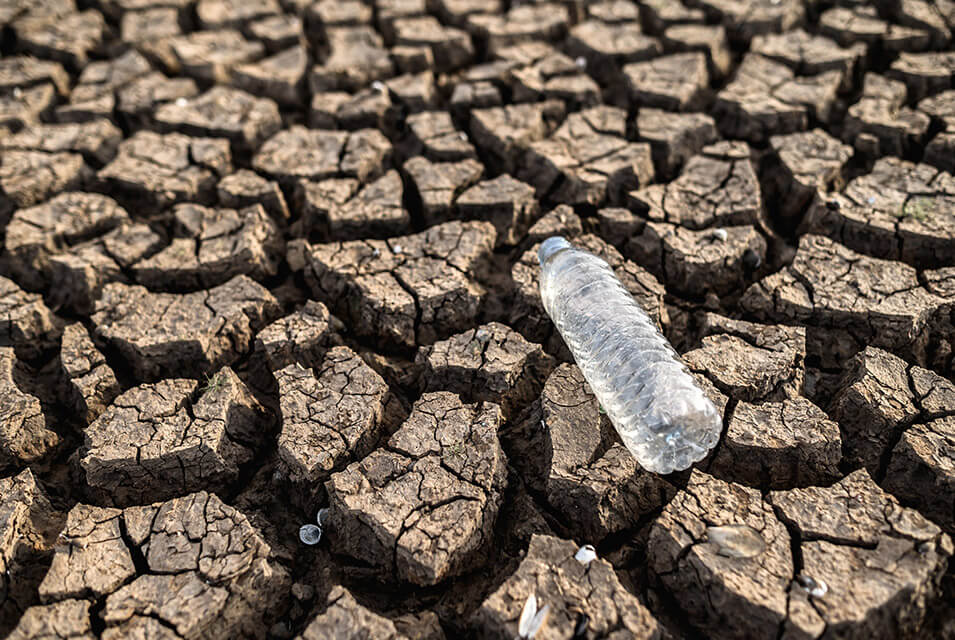 Botella de agua sobre suelo seco árido producto de la escasez de agua en México